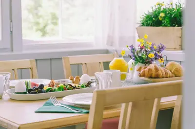 a table with a plate of food and bread and flowers at Steien Hotel in Alvdal