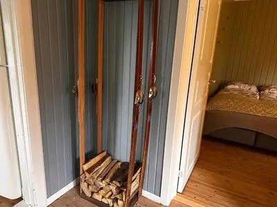 a room with a fireplace with skis in it at Charming family house near Kvitfjell in Ringebu