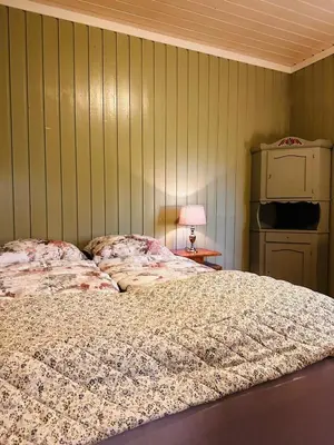 a bedroom with a bed and a table with a lamp at Charming family house near Kvitfjell in Ringebu