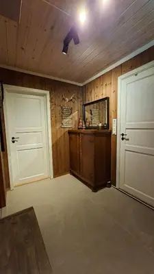 a room with two white doors and a mirror at Trivelig hytte med innlagt strøm og vann Perfekt for familietur Bilveg helt frem in Rotvolden
