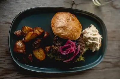 a plate of food with a sandwich and potatoes at Snerting Ranch Hotel - Comfty and modern Log House in Stokkan