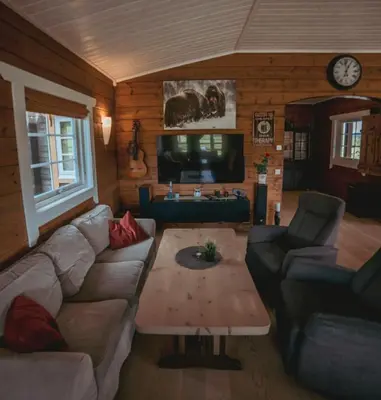 a living room with a couch and a coffee table at Snerting Ranch Hotel - Comfty and modern Log House in Stokkan