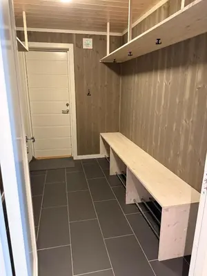 a locker room with a bench and a door at New cottage near the city center and ski slope in Hemsedal
