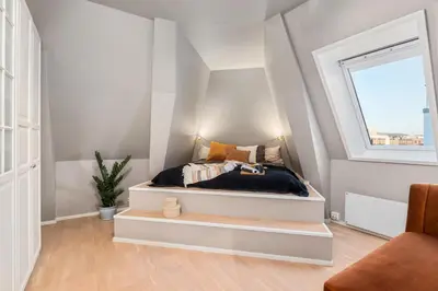 a bedroom with a bed with a window at Two bedroom penthouse with large living room and rooftop in the city centre of Trondheim in Trondheim
