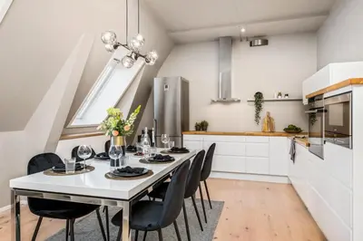 a dining room with a white table and chairs at Two bedroom penthouse with large living room and rooftop in the city centre of Trondheim in Trondheim