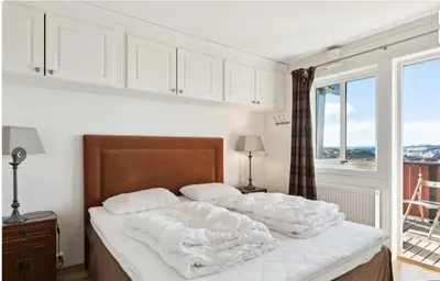 a bedroom with a bed with white sheets and a window at Family Friends, 3 Bedroom Apartment With Terrace in Beitostøl