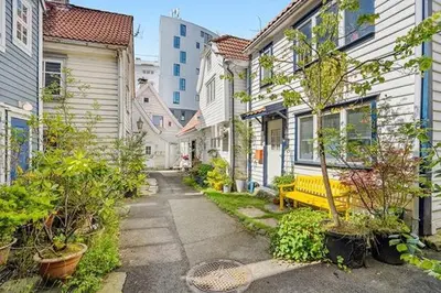 a street with houses and a yellow bench in a city at In the middle of Bergen City in a real Bergenshus from the 18th Century in Bergen