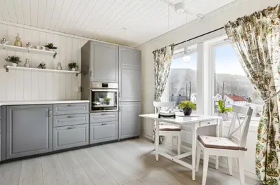 a kitchen with white cabinets and a table and a window at Spacious 3-Bedroom Apartment with Balcony and Free Parking Orkland near Trondheim in Fannrem