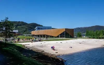 a group of people on a beach near the water at Spacious 3-Bedroom Apartment with Balcony and Free Parking Orkland near Trondheim in Fannrem