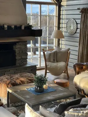 a living room with a fireplace and a table and chairs at No71 Golsfjellet in Golsfjellet
