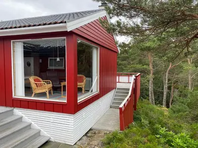 a red and white house with a table and chairs at Bjørnafjorden