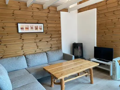 a living room with a couch and a wooden wall at Bjørnafjorden