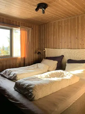 two beds in a room with wood paneling at Stylish Cabin With Lovely View At Stavadalen in Reinli