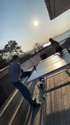 two men standing on top of a table on a roof at Casa Oyen in Ålesund