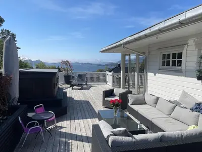 a patio with a couch and a table and chairs at Casa Oyen in Ålesund