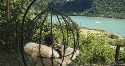 a woman sitting in a swing with sheep at Waterfall Retreat in Sel