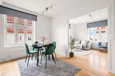 a dining room with a table and green chairs at Authentic Bergen Charm in Famous Neighborhood in Bergen