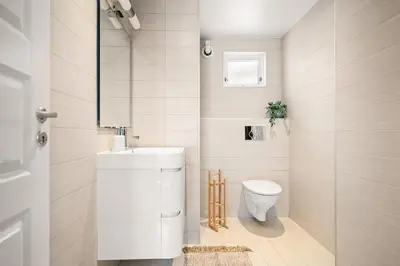 a white bathroom with a toilet and a sink at Authentic Bergen Charm in Famous Neighborhood in Bergen