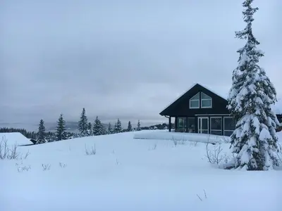a cabin in the snow with a christmas tree at Cabin With Panoramic Views In Hafjell in Øyer