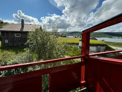 a red fence with a house in the background at Spacious Apartment By Hardangervidda National Park in Ustaoset