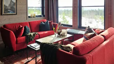 a living room with two red couches and a table at New Cabin With Panoramic Views Of Lake Osen