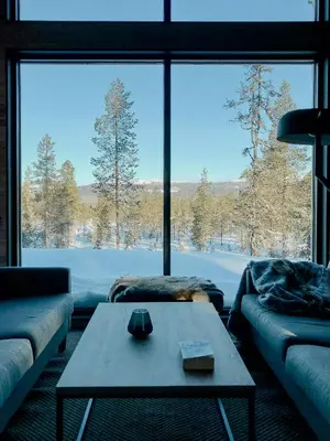 a living room with a table and a large window at Modern Cabin With Views Of Trysil Mountain in Trysil