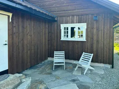 two chairs sitting outside of a building with a window at Family Cabin With Charm in Mesnali