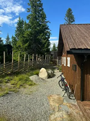 a bike parked next to a building with a fence at Family Cabin With Charm in Mesnali