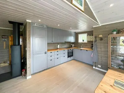 a kitchen with white cabinets and a wooden floor at Family Cabin In Rauland in Rauland