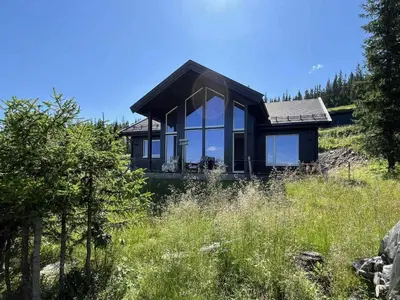 a small house on top of a hill with trees at Modern Cabin With Views Of Skeikampen in Svingvoll