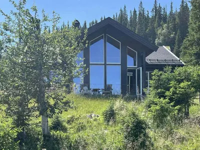 a house in the middle of a field with trees at Modern Cabin With Views Of Skeikampen in Svingvoll