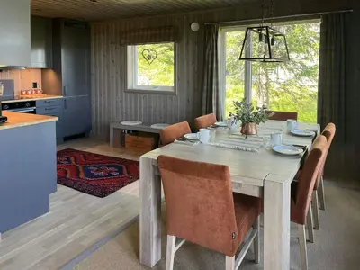 a kitchen and dining room with a table and chairs at Modern Cabin With Views Of Skeikampen in Svingvoll