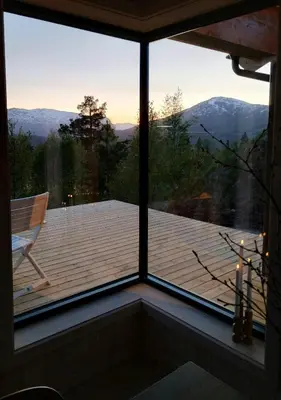 a room with a view of a deck with a chair at Mountain Cabin With View At Bjorli in Bjorli