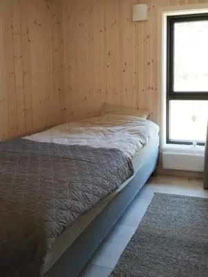 a bed in a wooden room with a window at Mountain Cabin With View At Bjorli in Bjorli