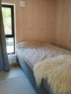 a bed in a wooden room with a window at Mountain Cabin With View At Bjorli in Bjorli