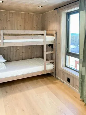 two bunk beds in a room with a window at Cabin With Views Over Hafjell And Gausdal in Svingvoll