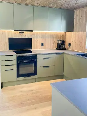 a kitchen with white cabinets and a stove top oven at Cabin With Views Over Hafjell And Gausdal in Svingvoll