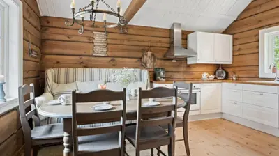 a kitchen and dining room with a table and chairs at Timber Cabin With Soul At Kvamskogen in Norheimsund