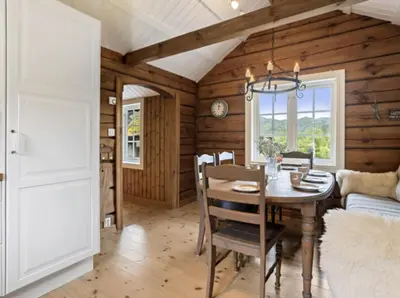 a dining room with a table and a couch at Timber Cabin With Soul At Kvamskogen in Norheimsund