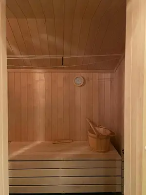 a sauna with a clock on the wall and a bucket at Mountain Cabin With Private Terrace By Mjogetjønn in Veggli