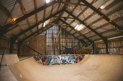 a skate park with a ramp with graffiti on it at Kommahuset in Ervik