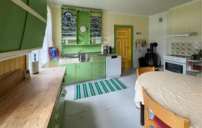 a kitchen with green cabinets and a bed in a room at 7 Bedroom Lovely Home In Tufsingdalen in Bakken