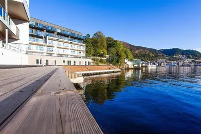 a building next to a body of water at Elegant city apartment in Bergen- Private outdoor patio and free parking in Bergen