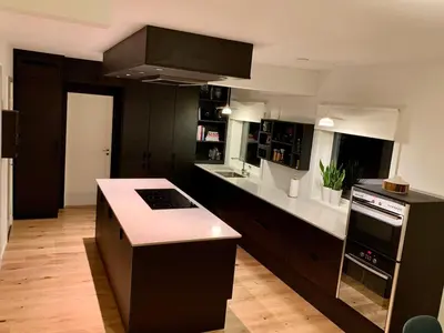 a kitchen with black cabinets and white counter tops at Large Architect Designed Home in City Centre in Hamar