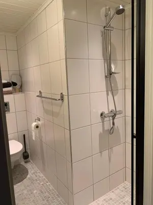 a shower with a glass door in a bathroom at Large Architect Designed Home in City Centre in Hamar
