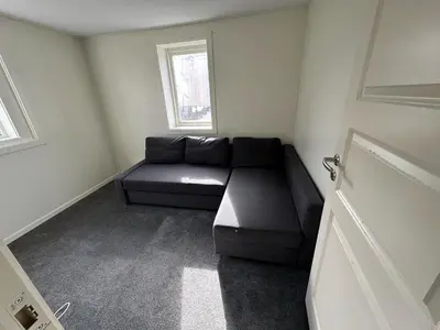 a black couch in a room with a window at Sula in Frøya