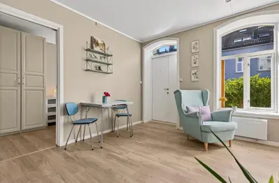a living room with a table and a chair at Eden Oasis, Bakklandet with Free parking! in Trondheim