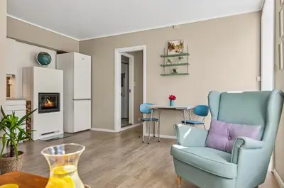 a living room with a blue chair and a table at Eden Oasis, Bakklandet with Free parking! in Trondheim