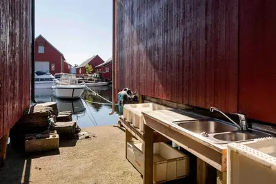 a kitchen with a sink and a boat in the water at Raffelbrygga in Bud