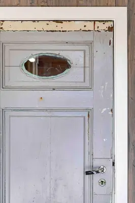 an old white door with a round window on it at Raffelbrygga in Bud